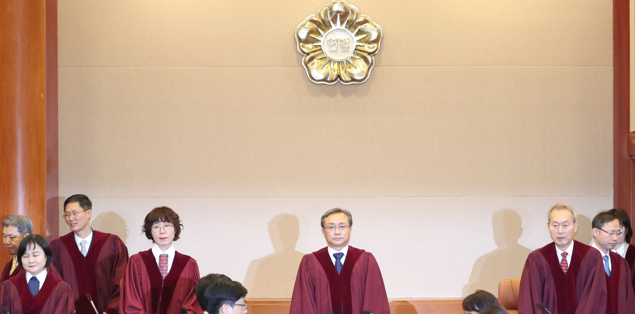 유남석 헌법재판소장(가운데)을 비롯한 헌법재판관들이 27일 오후 서울 종로구 헌법재판소 대심판정에 입장하고 있다. 이날 헌재는 박근혜 정부가 체결한 한·일 위안부 문제에 관한 합의가 헌법에 어긋나는지 결론을 내린다. 연합뉴스