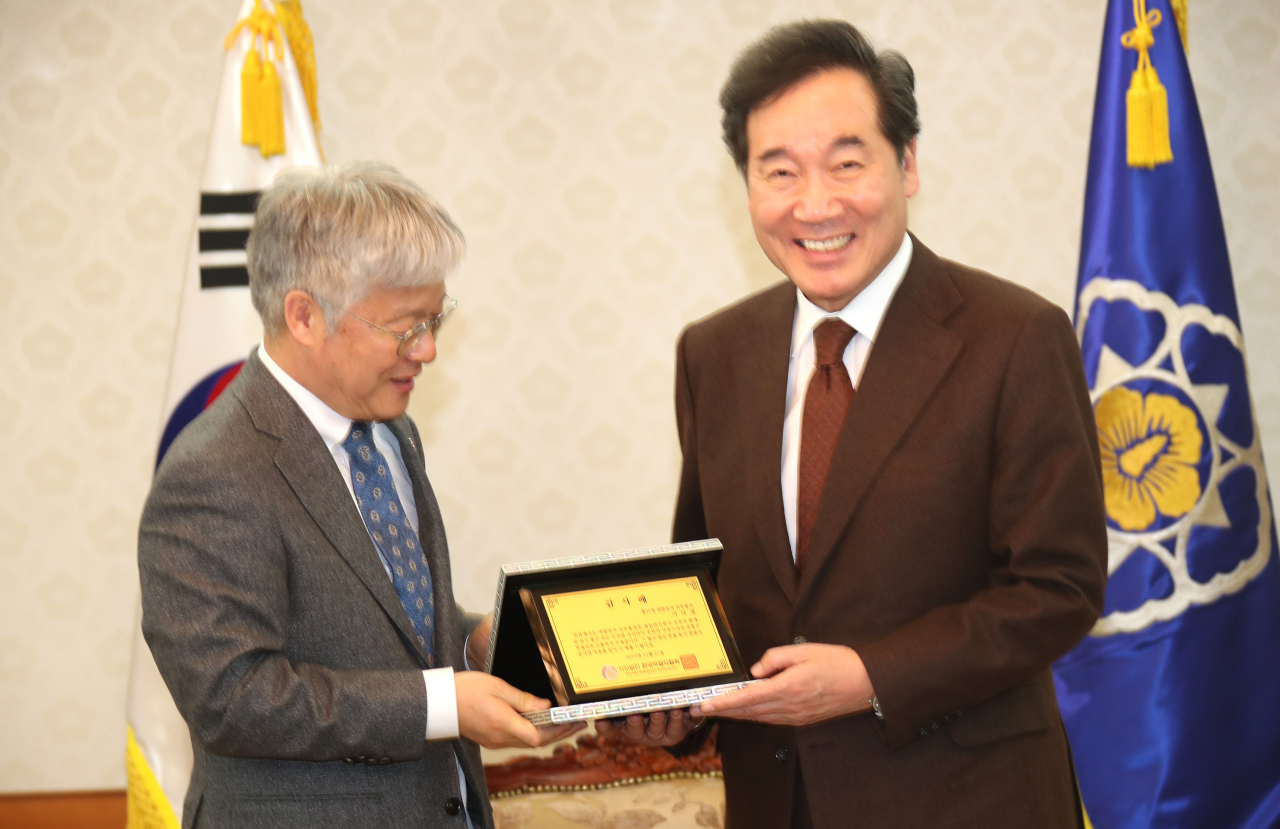 이낙연 국무총리가 27일 정부서울청사 접견실에서 정규성 한국막걸리협회 회장으로부터 감사패를 받고 있다.[연합]