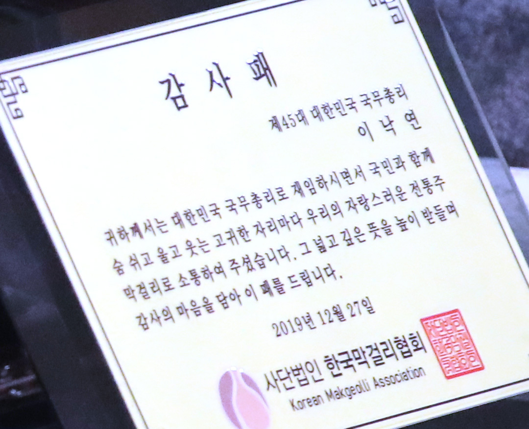 이낙연 국무총리가 27일 정부서울청사 접견실에서 정규성 한국막걸리협회 회장으로부터 받은 감사패. [연합]