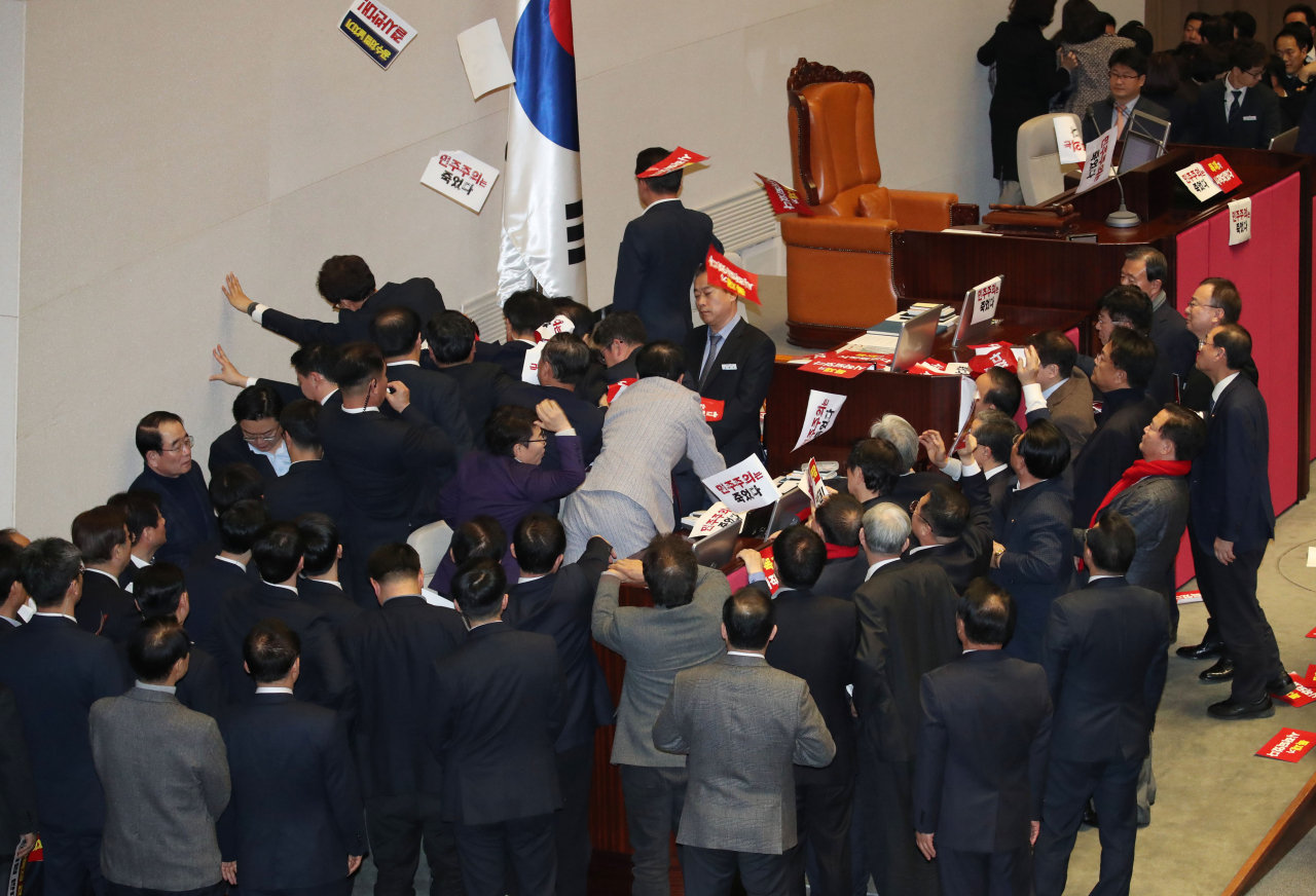 자유한국당 의원들이 27일 국회 본회의장에서 공직선거법 개정안 처리를 저지하기 위해 격렬한 몸싸움을 벌이고 있다 [연합]