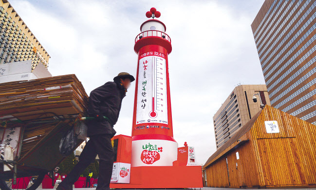 지난 12일 서울 종로구 광화문광장 사랑의 온도탑 앞으로 한 노인이 폐지를 리어카에 싣고 이동하고 있다. 박해묵 기자/mook@heraldcorp.com