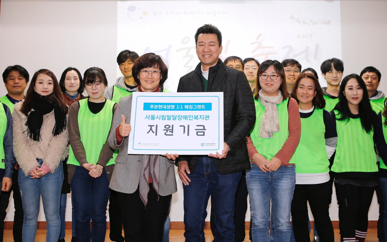 지난 21일 서울시립발달장애인복지관에서 개최된 ‘어울림 축제’에서 이재원 푸본현대생명 사장(앞줄 왼쪽에서 네번째)이 ‘1:1 매칭그랜트’ 제도와 ‘급여 끝전 모으기’를 통해 모금된 기부금을 서울시립발달장애인복지관 최선자 관장(앞줄 왼쪽에서 세번째)에게 전달하였다. [사진제공 푸본현대생명]