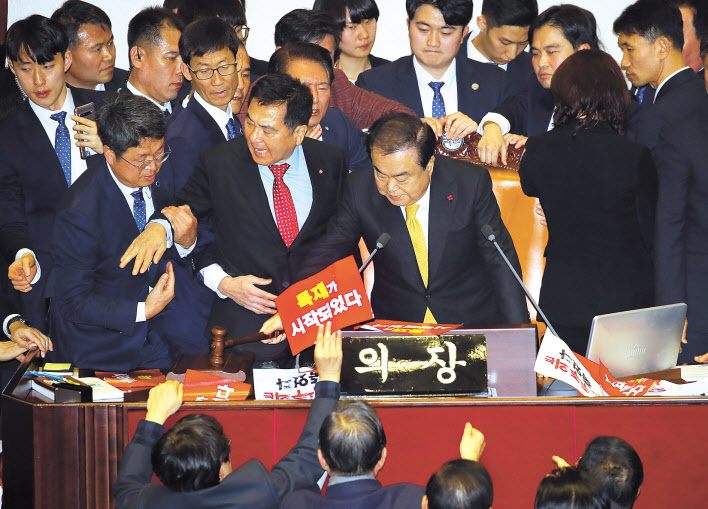 ‘공직선거법 개정안’이 통과된 지난 27일 국회 본회의에서 문희상 국회의장이 의사봉을 두드리는 동안 자유한국당 심재철 원내대표가 거세게 항의하다 제지당하고 있다. [연합]