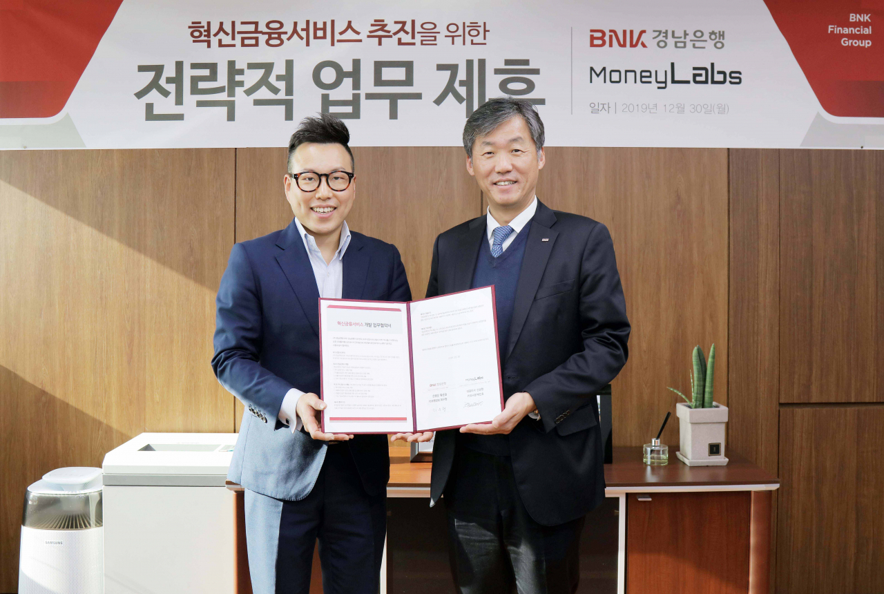 30일 BNK경남은행 본점에서 최우형 부행장보(사진 오른쪽)가 ㈜머니랩스 백인호 부사장과 ‘혁신금융서비스 개발을 위한 업무 협약’을 체결하고 있다.