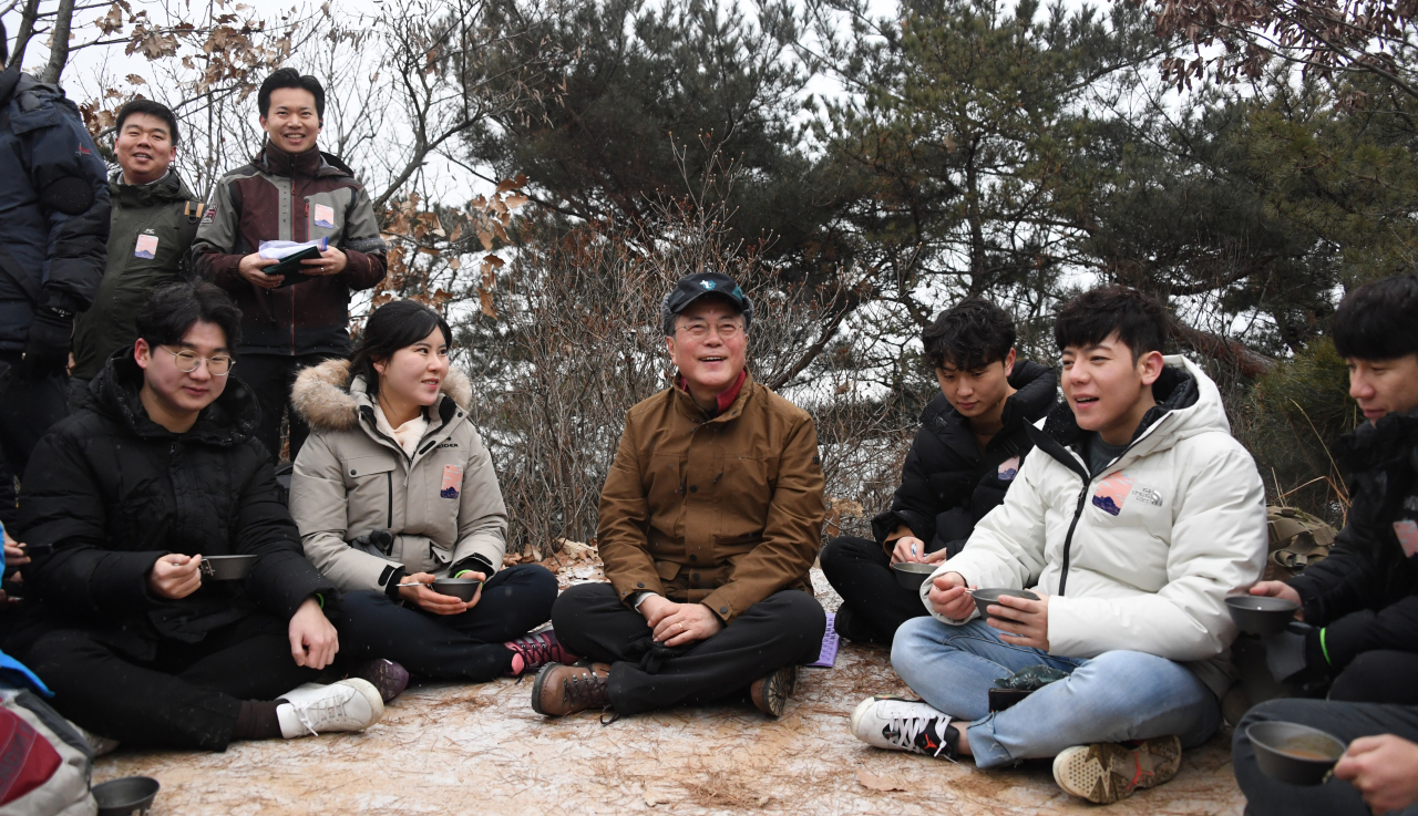 문재인 대통령이 2020년 새해 첫날인 1일 아차산에서 2019년을 빛낸 의인들과 해맞이 산행 중 대화하며 잠시 쉬고 있다. [연합]