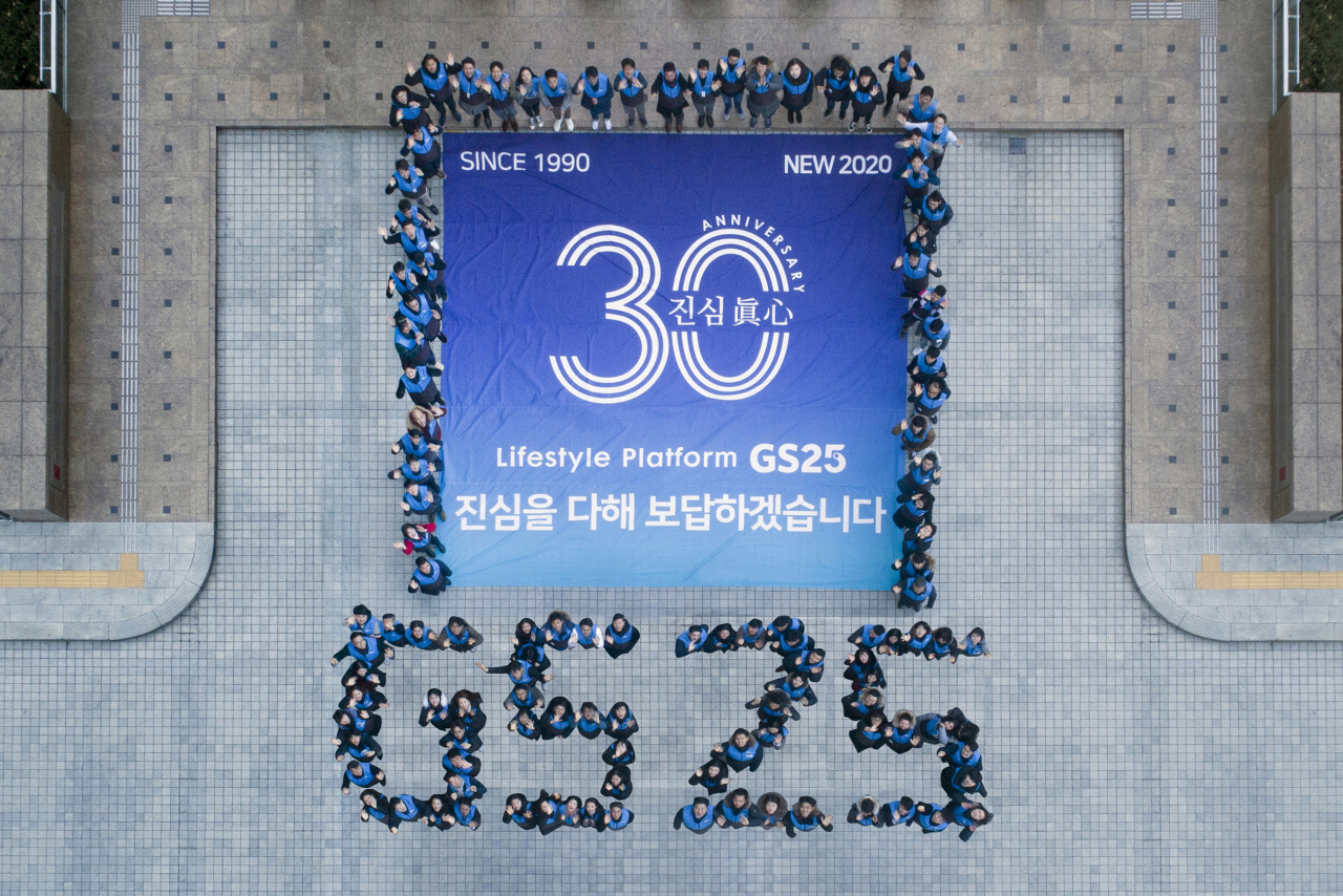역삼동 GS타워에서 GS25 임직원들이 모여 기념 현수막과 GS25 글자를 만들며 기념사진을 찍고 있다. [GS리테일 제공]