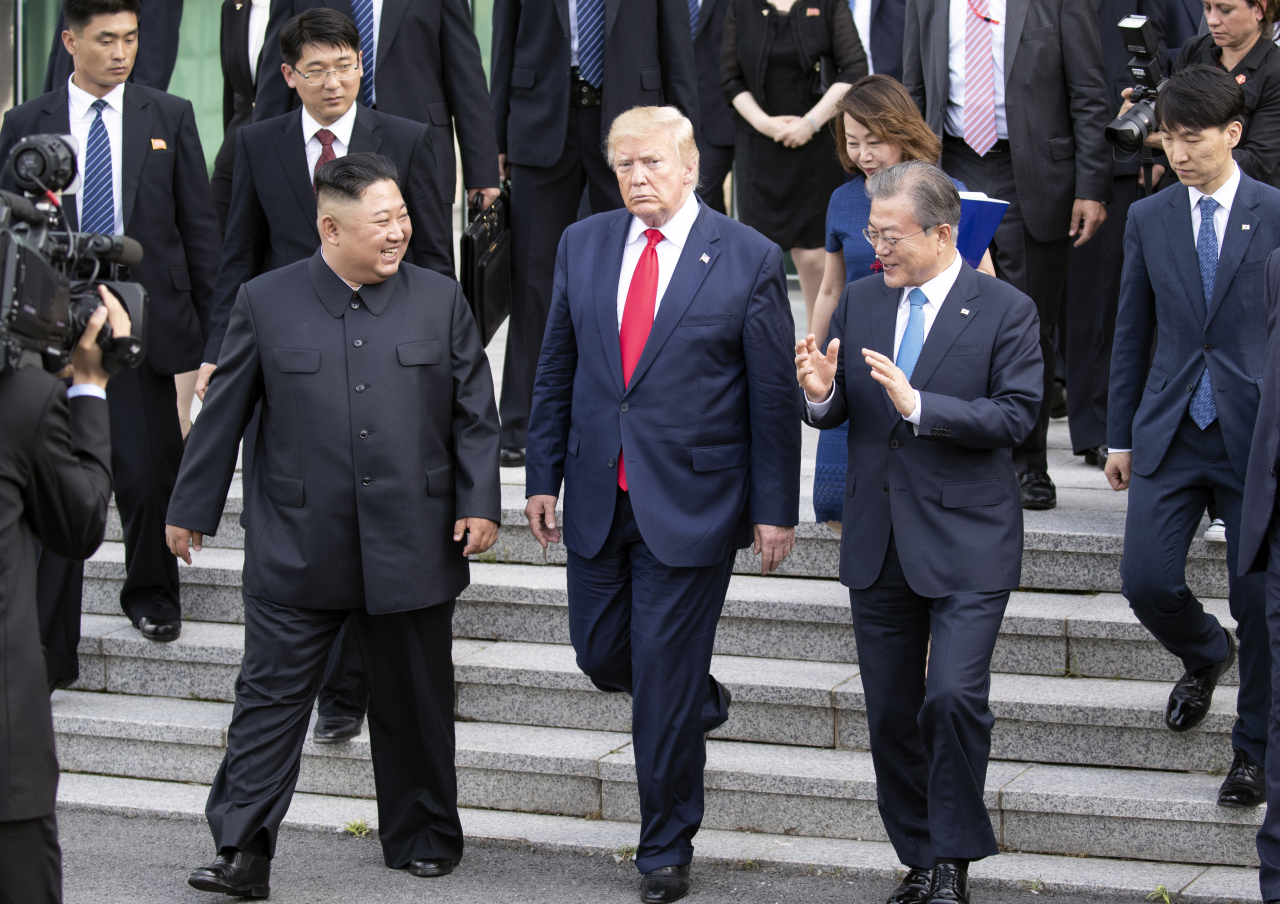 김정은 북한 국무위원장이 최근 진행된 제7기 5차 전원회의 보고에서 선제적 비핵화 조치로 진행해 온 '핵실험 및 대륙간탄도미사일 시험 발사 중단' 결정을 폐기할 것임을 시사했다. 이에 한미 양국은 대북 공조의 중요성을 강조하며 공동 대응 방안을 계속 논의키로 했다. 사진은 지난해 6월 진행된 남북미 판문점 회동에서 이야기를 나누는 문재인 대통령, 트럼프 미국 대통령, 김정은 위원장. [연합]