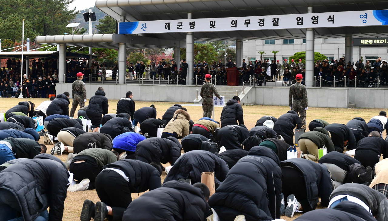 경남 창원시 진해구 해군교육사령부 연병장에서 지난 11월 열린 해군병 및 의경 입영식에서 입영 대상자들이 부모와 지인에게 큰절하고 있다.[연합]