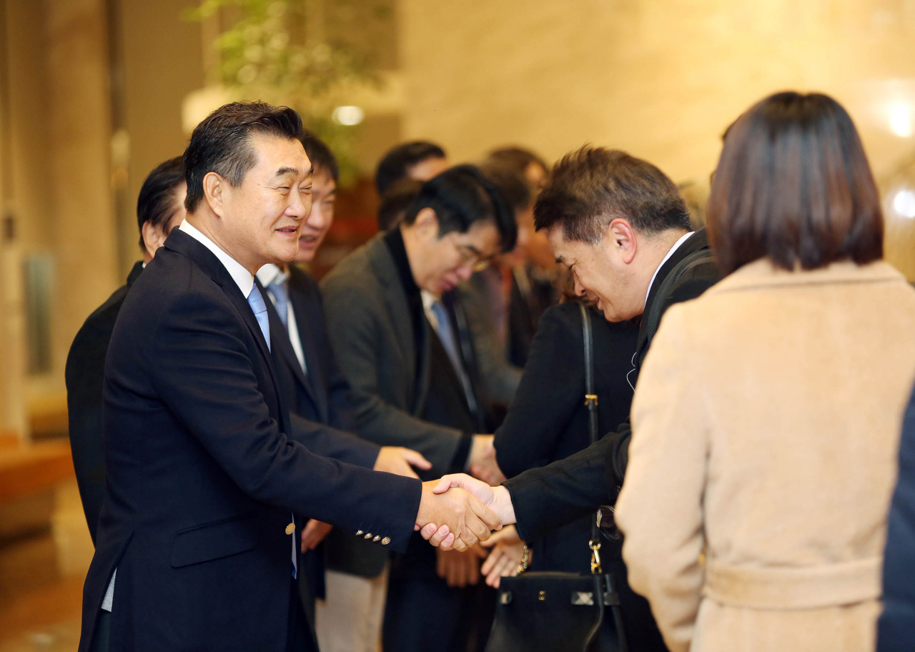 유경선 유진그룹 회장(왼쪽)이 2일 서울 여의도 본사에서 출근하는 직원들과 악수를 나누고 있다
