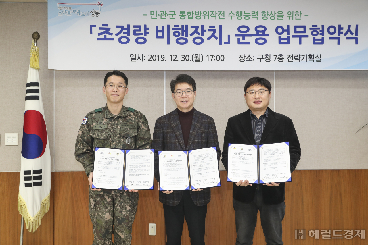 (왼쪽부터) 윤종욱 육군제3298부대 2대대장, 정원오 성동구청장, 조현준 드론스쿨 대표가 협약서를 들어보이고 있다. [성동구 제공]