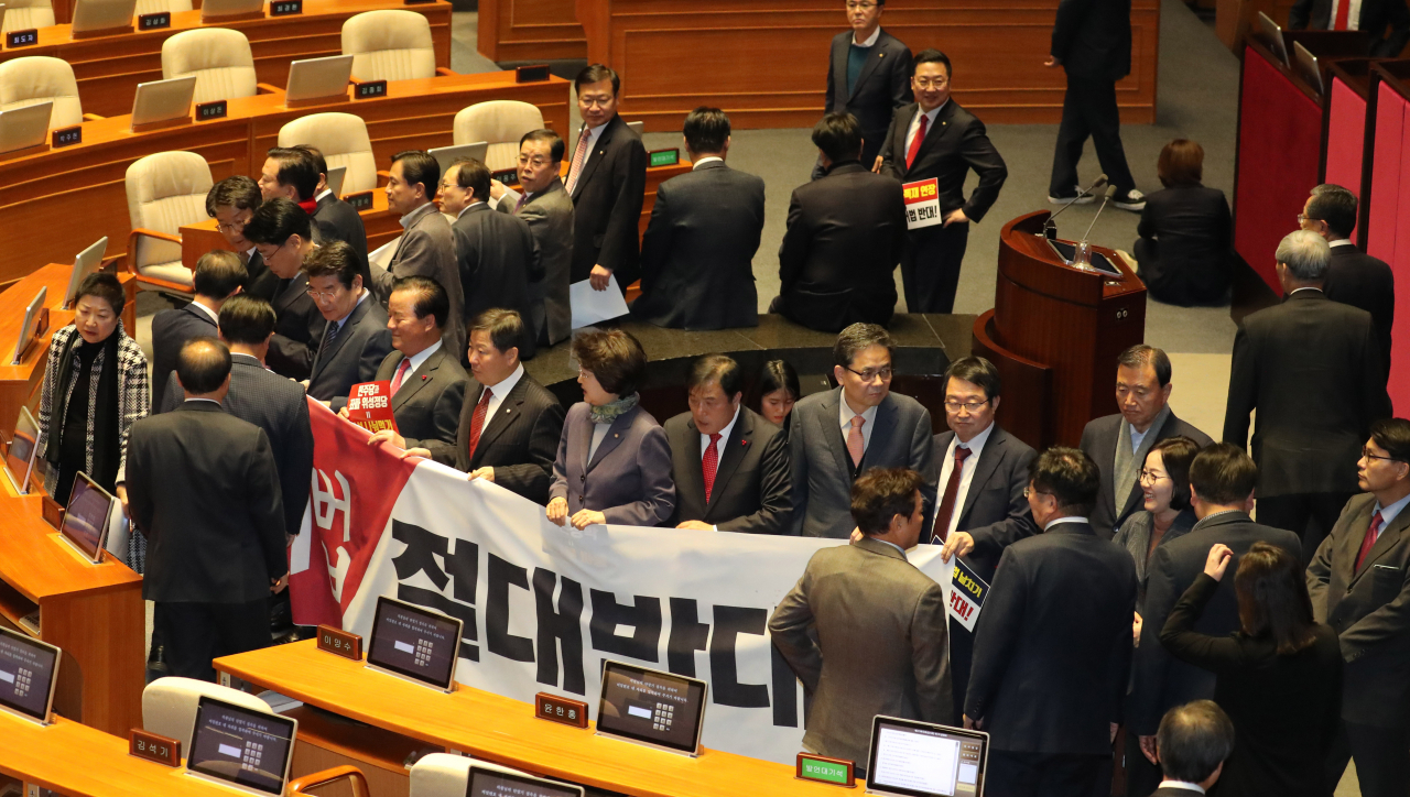 자유한국당 의원들이 지난달 27일 오후 국회 본회의가 열리기에 앞서 '연동형비례대표제' 선거법 반대 현수막을 펼치고 의장석 주변을 둘러싸고 있다. [연합]