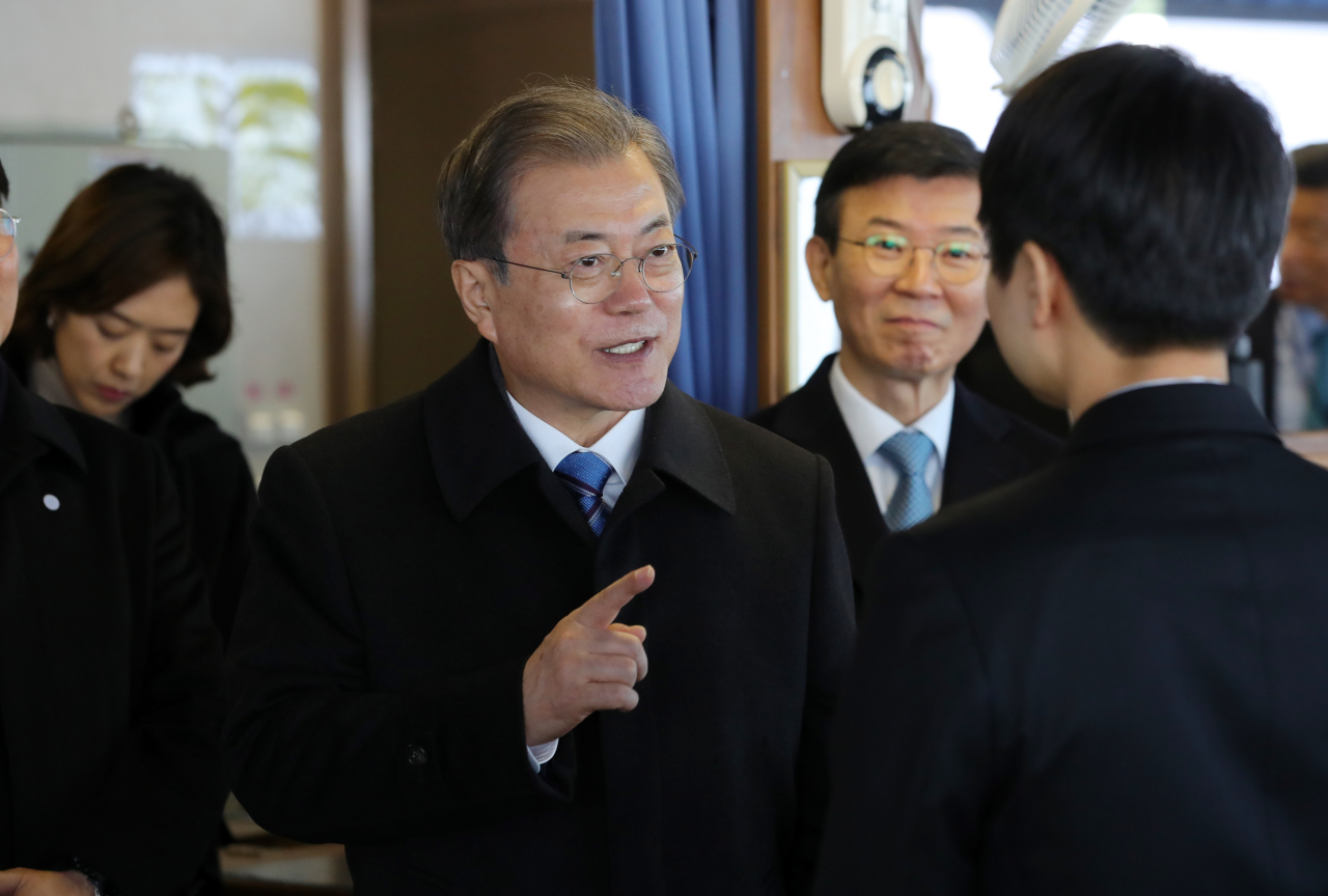 President Moon Jae-in speaks with the captain of the automobile carrier at the Pyeongtaek-Dangjin port on Friday. Yonhap