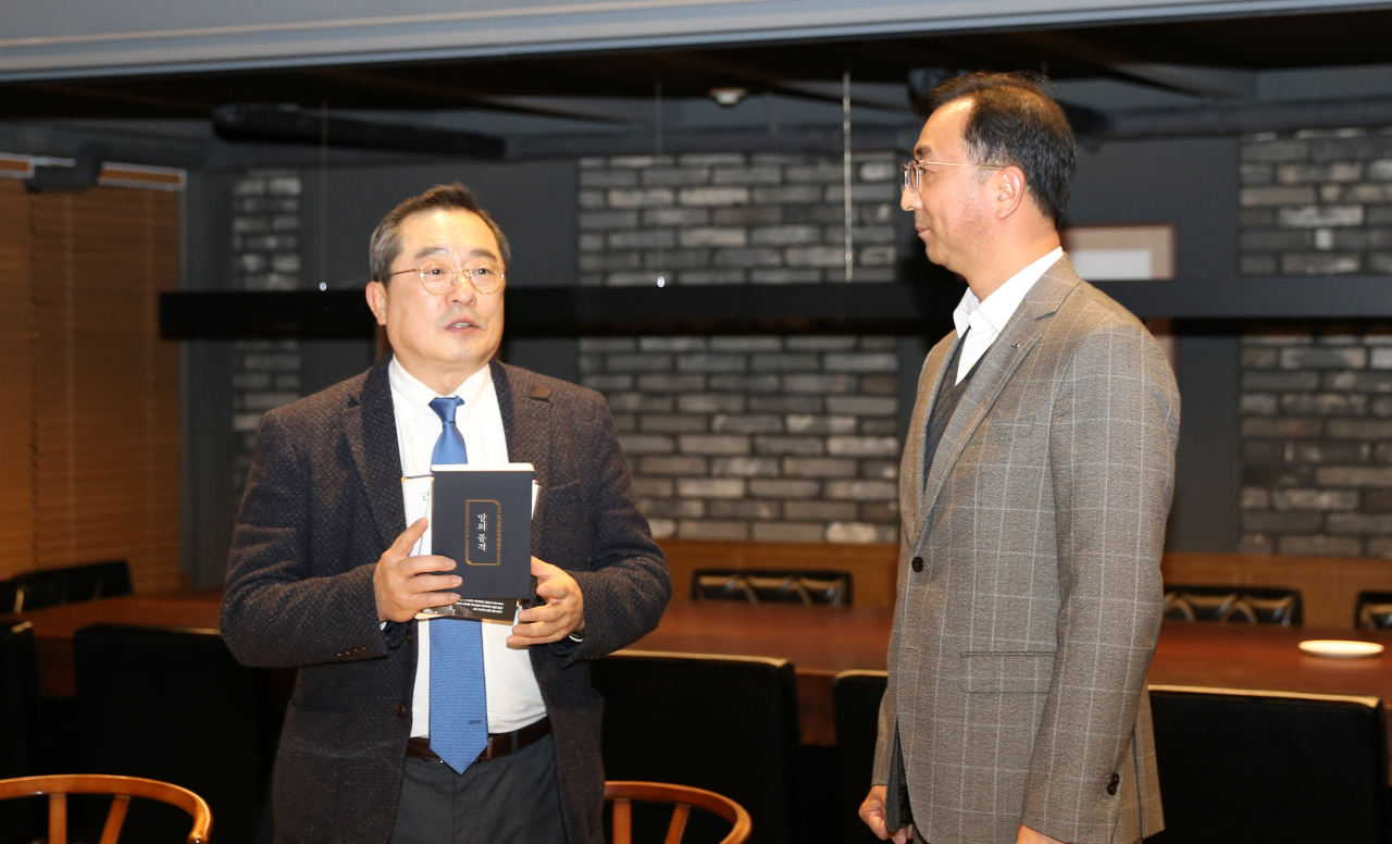 구자열 LS그룹 회장(왼쪽)이 6일 신규 임원이 된 LS전선 박현호 이사(LSCI법인장)에게 책을 선물하고 있다. [LS그룹 제공]