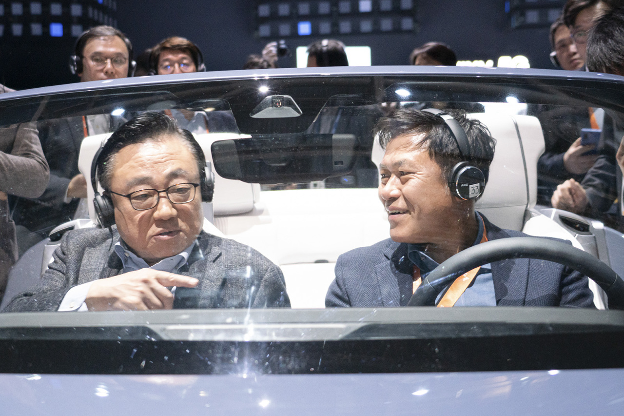 Koh Dong-jin (left), Samsung Electronics IT and mobile communications CEO, and Park Jung-ho, SK Telecom CEO, test-ride a newly developed digital cockpit, co-designed by Samsung Electronics and Harman International, at Samsung’s CES 2020 booth at the Las Vegas Convention Center on Tuesday. (Yonhap)