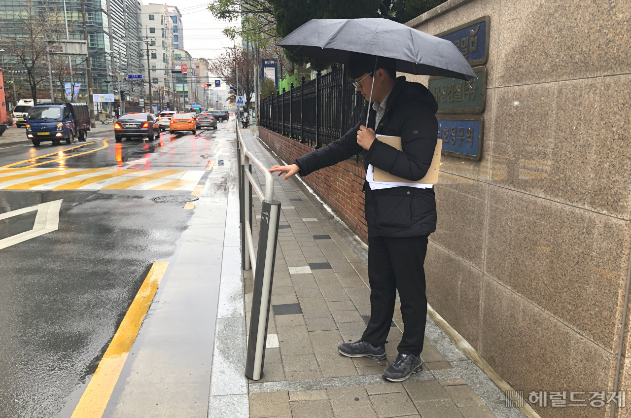 구청 직원이 학교 주변 통학로 안전펜스가 휘어있는 것을 살펴보고 있다. [영등포구 제공]