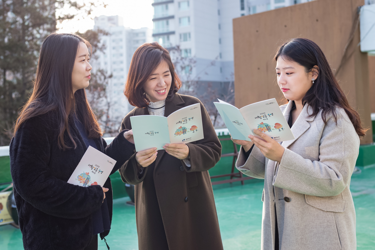 2020년 광진구 생활임금 운영 매뉴얼을 보고 있는 광진구청 직원들. [광진구 제공]