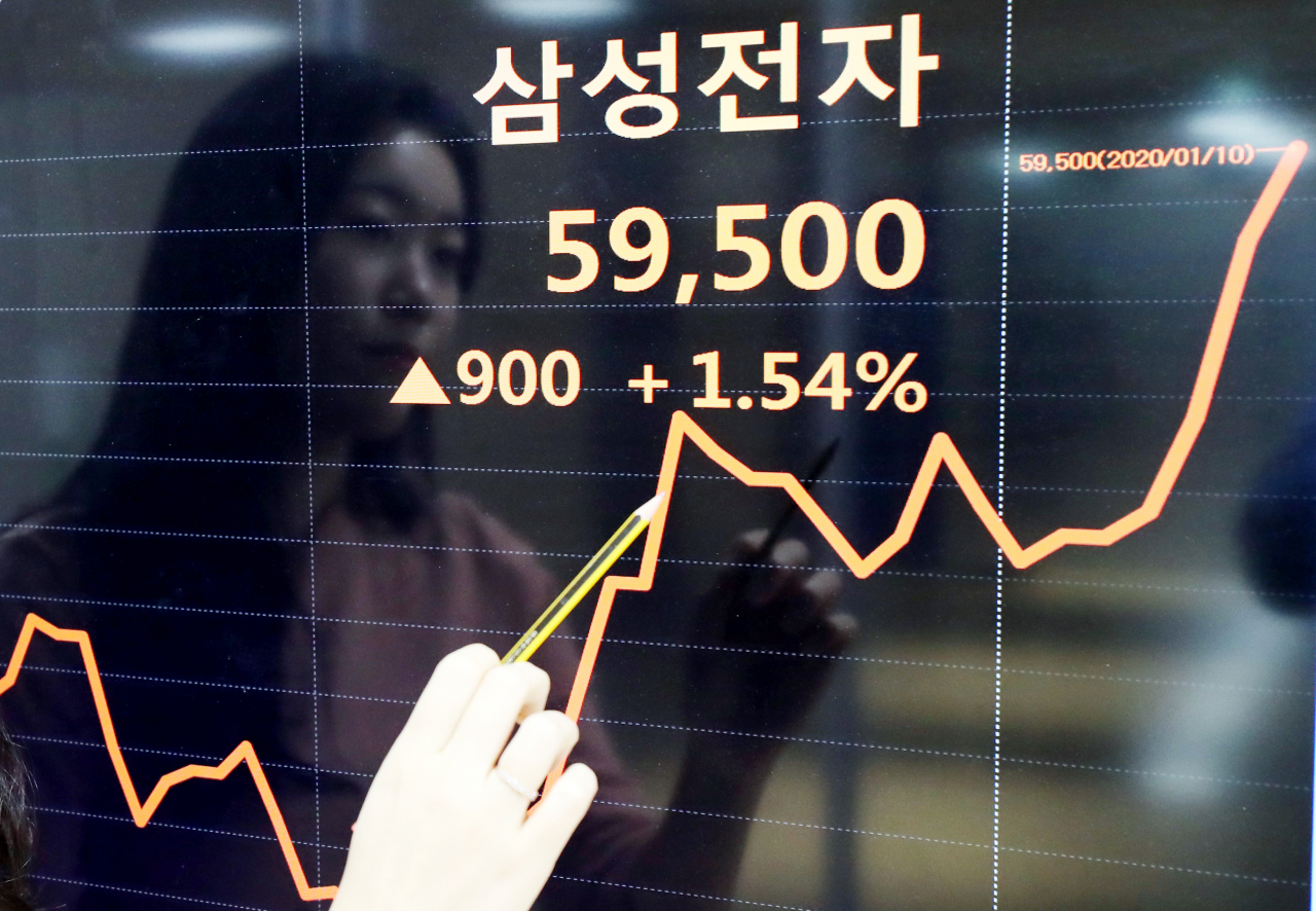 10일 서울 종로구 연합인포맥스에서 직원이 삼성전자 주식 변동 그래프를 살펴보고 있다. 이날 삼성전자 주가는 반도체 업황 개선 기대감에 전 거래일보다 1.54% 오른 5만9500원에 거래를 마감해 사상 최고가를 경신했다. [연합뉴스]