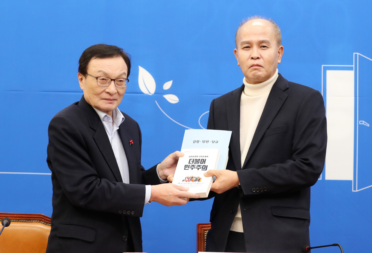 더불어민주당 이해찬 대표가 12일 오후 서울 여의도 국회에서 민주당 인재영입 7호인 이용우 카카오뱅크 공동대표에게 당원교과서 등을 전달하고 있다. 연합뉴스