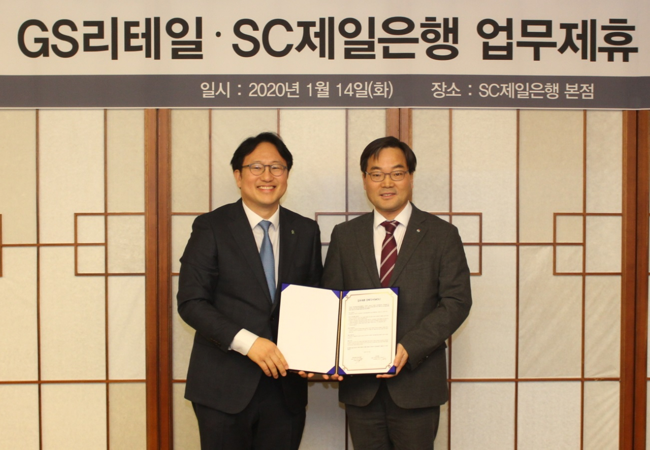 지난 14일 서울 종로구 SC제일은행 본사에서 장호준 SC제일은행 리테일금융총괄본부 부행장(왼쪽)과 김종수 GS리테일 MD본부장이 양사 간 업무 제휴 양해각서(MOU)에 서명한 후 기념 촬영을 하고 있다. [SC제일은행 제공]