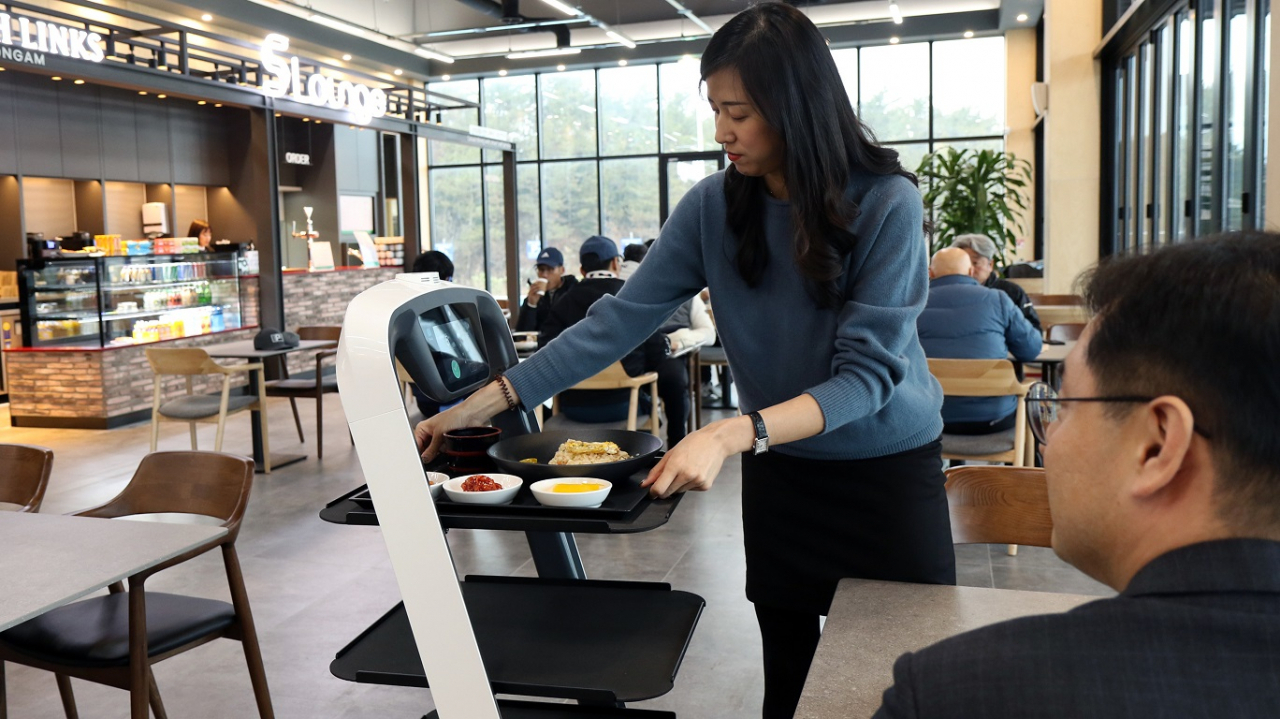고객이 서빙로봇에서 음식을 꺼내는 모습 [제공=CJ프레시웨이]