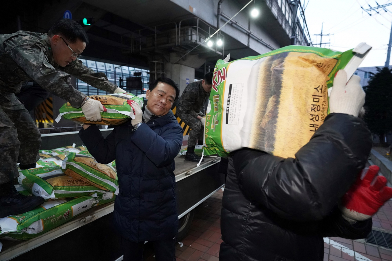 이승로(가운데) 구청장이 16일 월곡2동 주민센터 앞에서 새벽 얼굴없는 천사가 보낸 쌀을 실어나르고 있다. [성북구 제공]