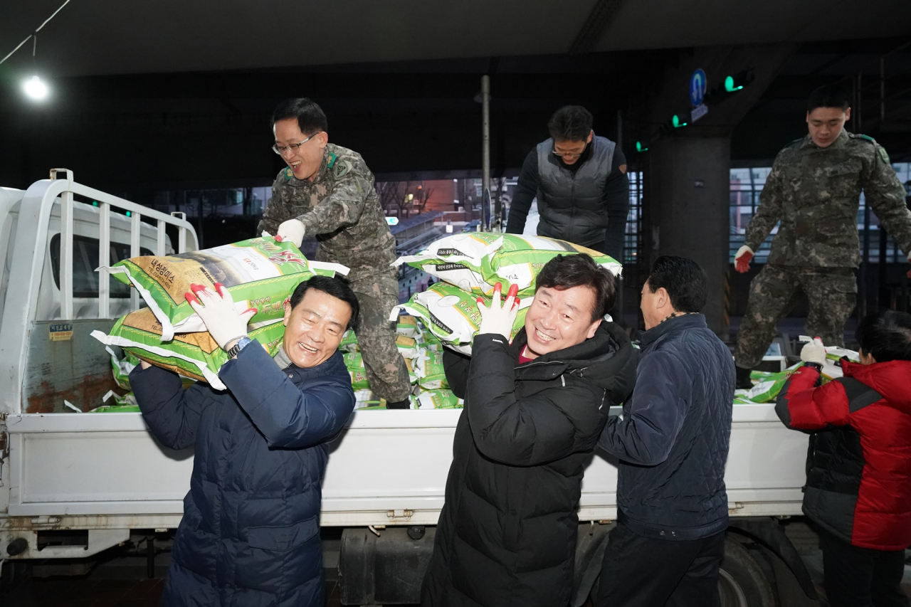 주민, 공무원, 군인 등이 하나되어 쌀을 옮기고 있다. [성북구 제공]