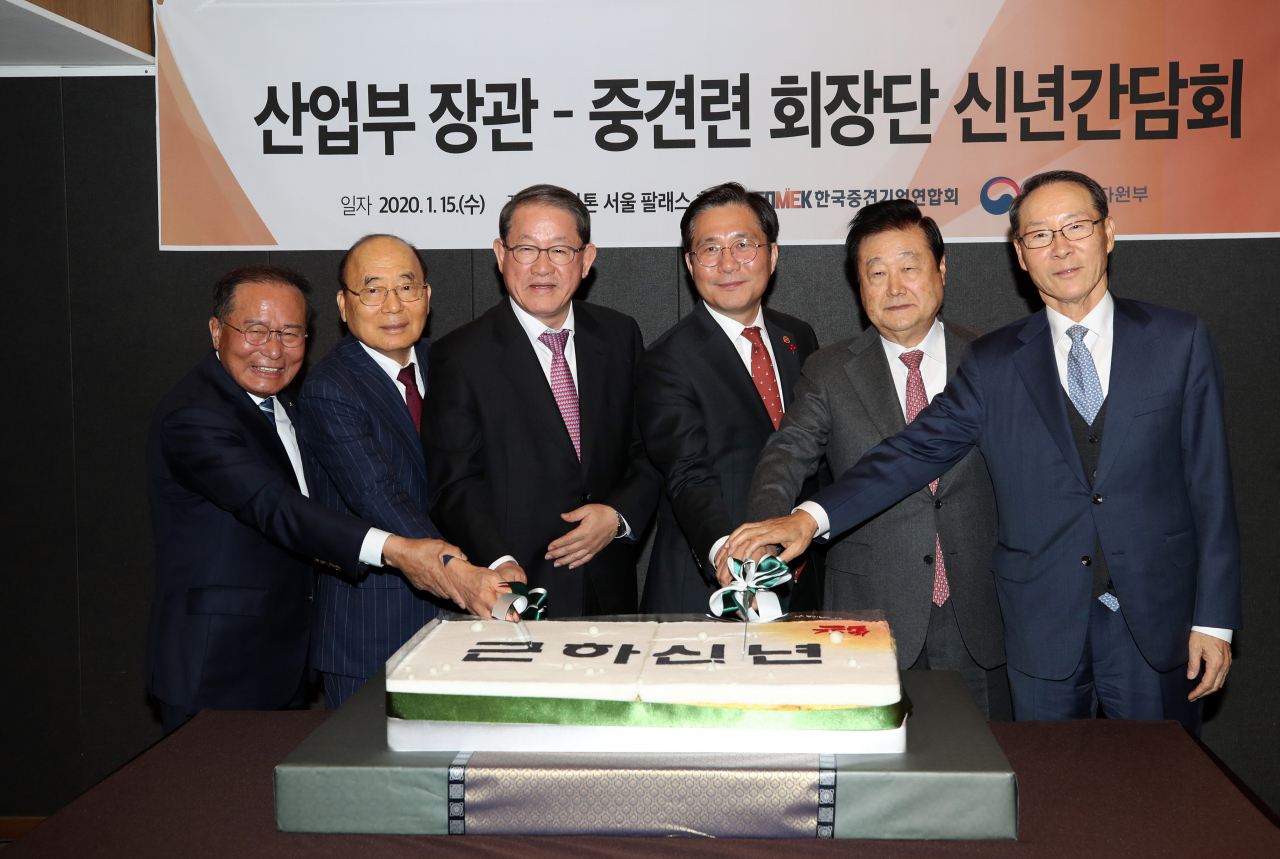 성윤모 산업통상자원부 장관(오른쪽 세번째)과 강호갑 한국중견기업연합회장(왼쪽 세번째)이 15일 쉐라톤 서울 팔래스 강남호텔에서 열린 '산업부 장관-한국중견기업연합회 회장단 신년간담회'에 참석해 떡케이크를 자르고 있다. 성 장관은 이 자리에서 “올해는 수출 플러스 조기 전환, 투자 활성화, 소재·부품·장비 육성을 통한 흔들리지 않는 산업구조 확립을 위해 정책 역량을 집중하겠다”고 강조했다. [연합]