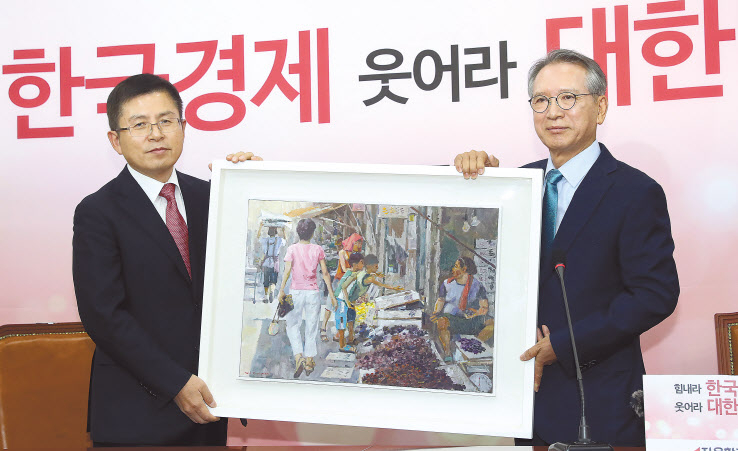 자유한국당 공천관리위원회 위원장으로 임명된 김형오 전 국회의장(오른쪽)이 17일 오전 국회에서 황교안 대표와 첫 회동을 하며 서민의 삶을 담은 그림을 선물하고 있다. [연합]