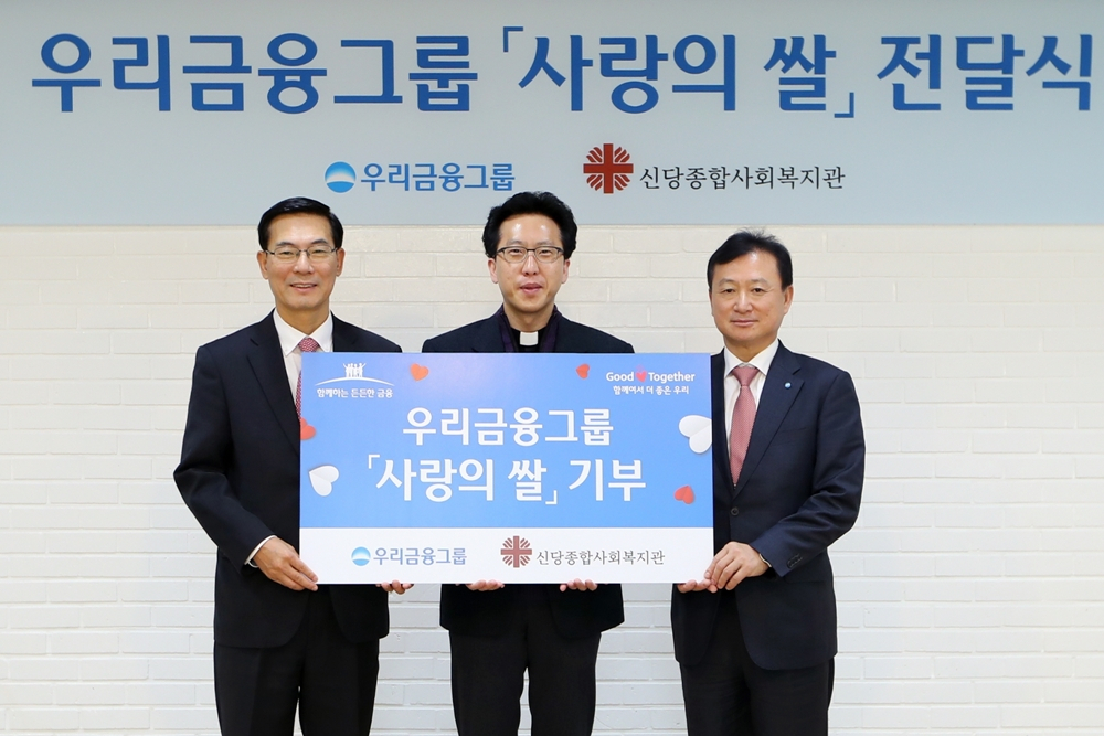 우리금융그룹은 16일 서울 신당종합사회복지관에서 사랑을 쌀을 전달했다. 이날 전달식에서 최동수 우리금융 경영지원총괄 부사장, 오대일 신당종합사회복지관 신부, 조수형 우리은행 소비자브랜드그룹 부행장(왼쪽부터) 기념사진을 찍고있다. [우리금융 제공]