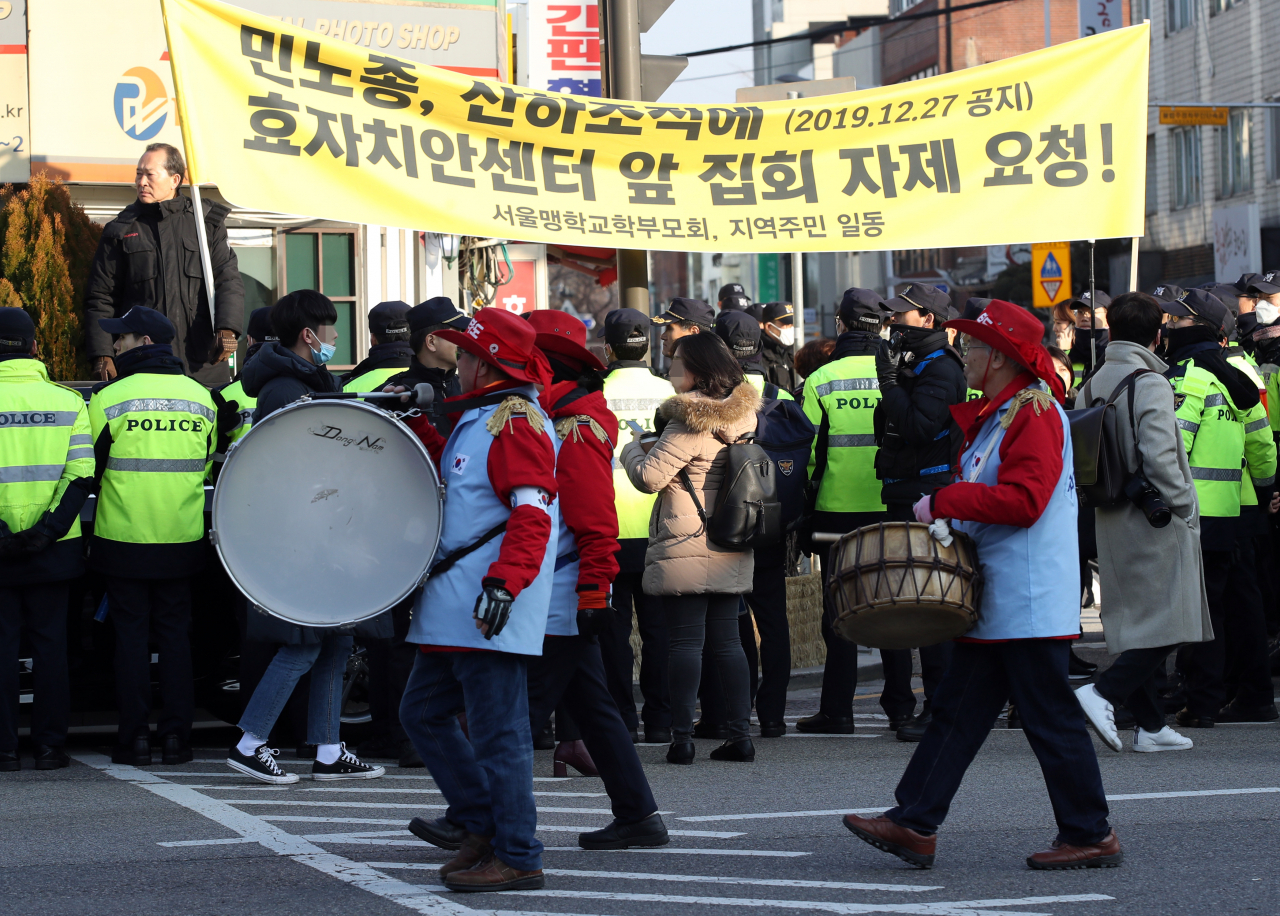 지난 4일 오후 서울 종로구 자하문로 일대에서 보수단체 등이 청와대 부근으로 행진하는 가운데 서울맹학교 학부모회, 지역주민 등이 효자치안센터 앞 집회 자제를 요청하는 현수막을 들고 있다. [연합뉴스]