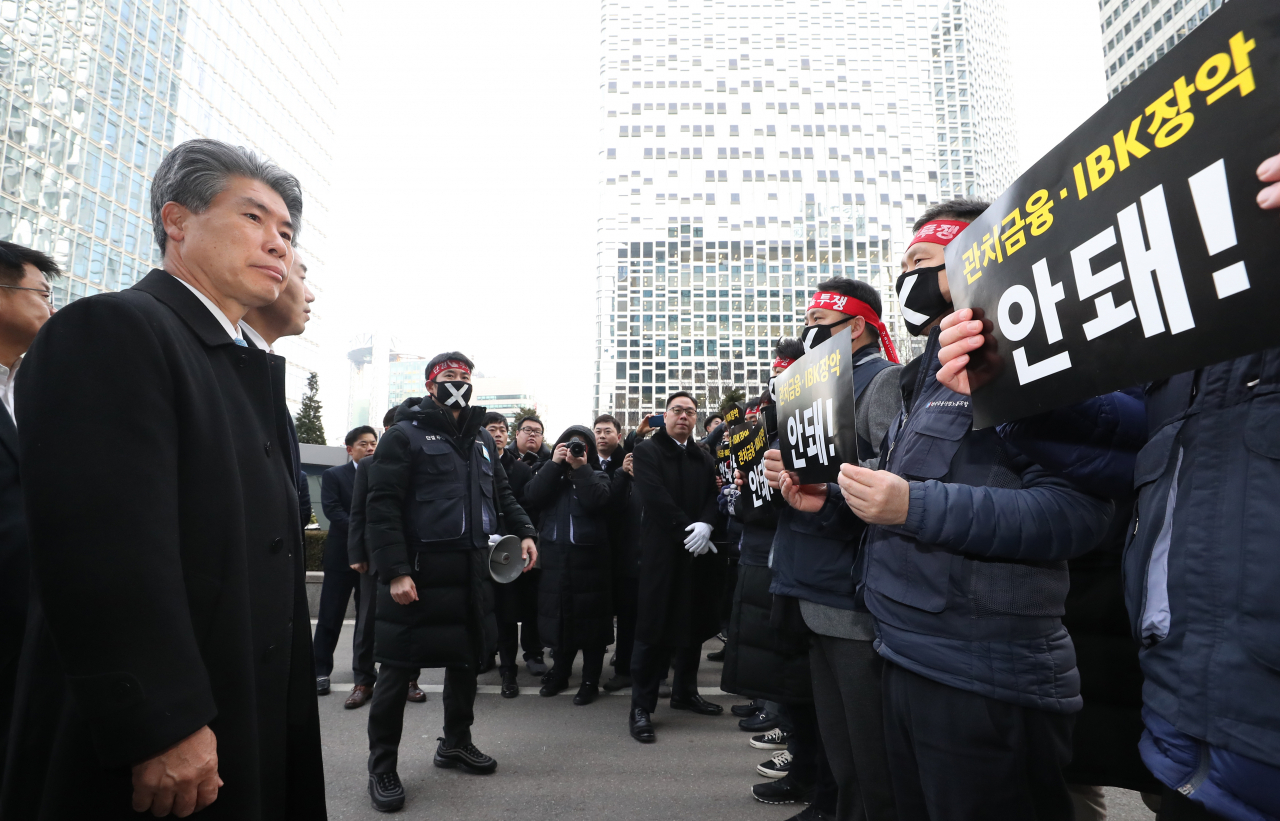 지난 16일 오전 서울 중구 IBK기업은행 본점에서 피켓을 든 노조원들이 윤종원 기업은행장의 출근을 저지하고 있다. [연합]
