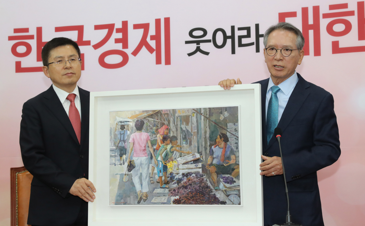 자유한국당 공천관리위원회 위원장으로 임명된 김형오 전 국회의장이 17일 오전 서울 여의도 국회에서 황교안 대표와 첫 회동을 하며 서민의 삶을 담은 그림을 선물하고 있다. [연합]