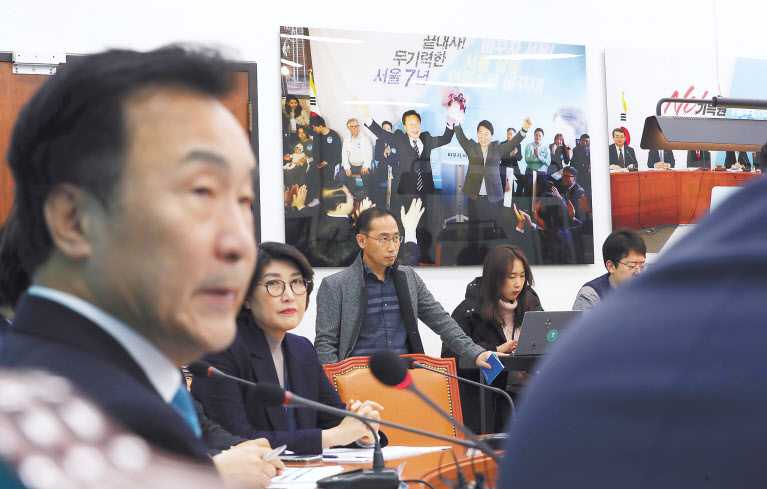 손학규 바른미래당 대표(왼쪽)가 20일 오전 국회에서 열린 최고위원회의에 참석했다. 손 대표 건너 벽엔 손 대표와 안철수 전 의원이 지난 2018년 서울시장 선거 때 손잡은 사진이 걸려 있다. 당시 안 전 의원은 바른미래당 서울시장 후보, 손 대표는 선거대책위원장이었다. [연합]