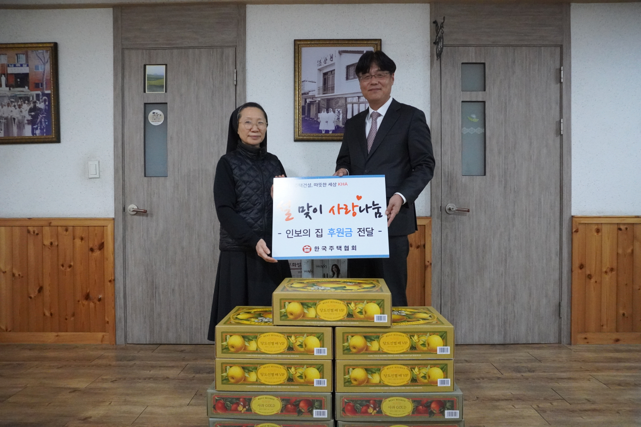 김형렬 한국주택협회 상근부회장(오른쪽)이 인보의 집에 후원금과 과일을 전달하고 있다. [한국주택협회]