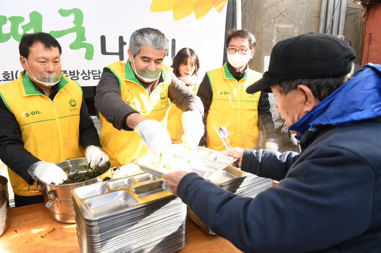 후세인 알 카타니 S-Oil 대표이사(가운데)가 쪽방촌 거주 독거노인, 장애인, 주변 지역 노숙자들에게 떡국을 나눠주고 있다. [S-oil 제공]
