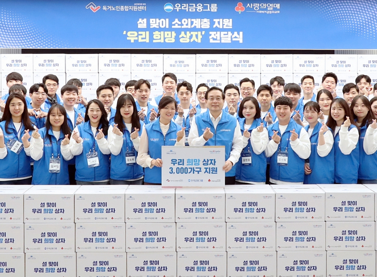 20일 서울 우리은행 본점에서 열린 ‘우리희망상자’ 전달식에서 손태승 우리금융 회장과 김현미 독거노인종합지원센터 센터장이 우리금융 신입직원들과 기념촬영을 하고 있다. [우리금융 제공]