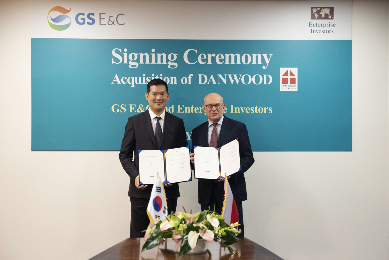 허윤홍 GS건설 사장(왼쪽)이 20일(현지시각) 폴란드 단우드 본사에서 열린 인수 축하 행사에서 야첵 스비츠키 단우드 사장(오른쪽)과 함께 인수를 마무리하는 서류에 서명 후 기념촬영 하고 있다. [사진=GS건설 제공]
