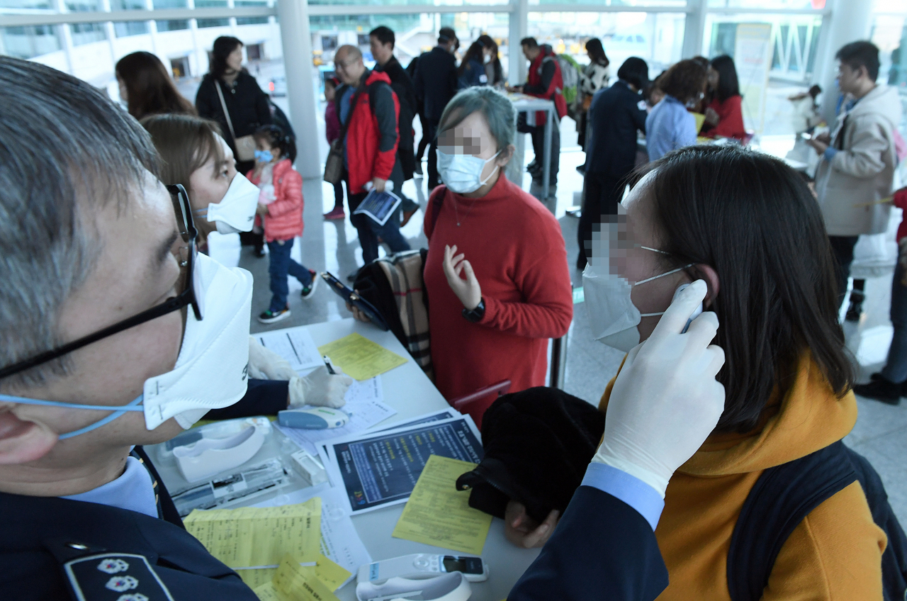 20일 오후 인천국제공항 제2터미널 입국장에서 질병관리본부 국립검역소 직원들이 우한발 비행기 입국자들을 발열 검사하고 있다. 질병관리본부는 중국 우한에서 인천공항으로 입국한 중국 국적 여성이 우한 폐렴으로 불리는 신종 코로나바이러스에 감염됐다고 19일 밝혔다. 연합뉴스