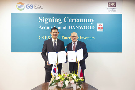 허윤홍 GS건설 사장(왼쪽)이 20일(현지시각) 폴란드 단우드 본사에서 열린 인수 축하 행사에서 야첵 스비츠키 단우드 사장과 함께 인수를 마무리하는 서류에 서명 후 기념촬영 하고 있다. [GS건설 제공]