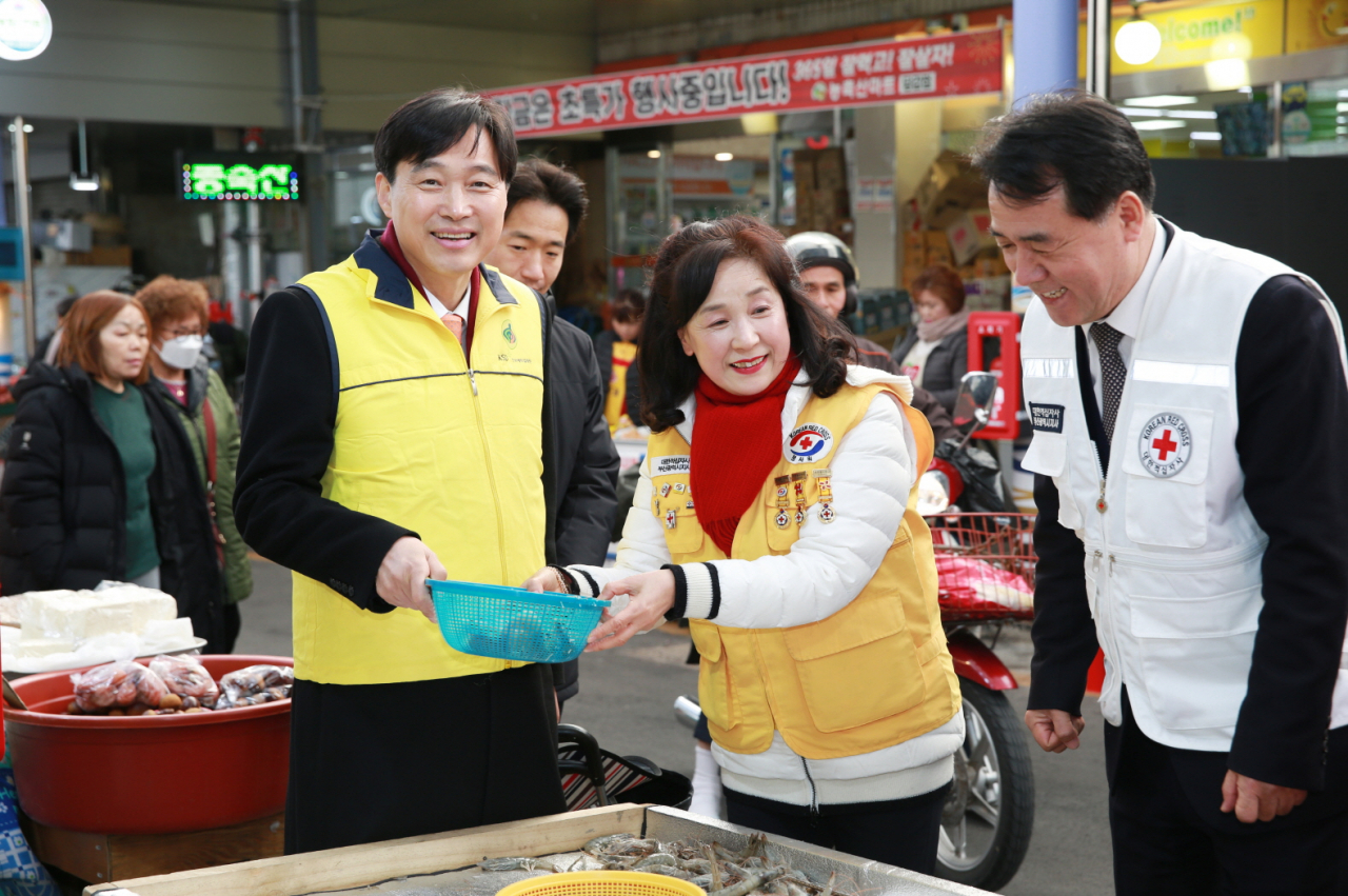 지난 20일 한국예탁결제원이 부산 당감시장에서 실시한 설맞이 전통시장 장보기 행사에서 이병래 한국예탁결제원 사장(왼쪽)과 조호규 대한적십자사 사무처장(오른쪽)이 물건을 구매하고 있다. [한국예탁결제원 제공]