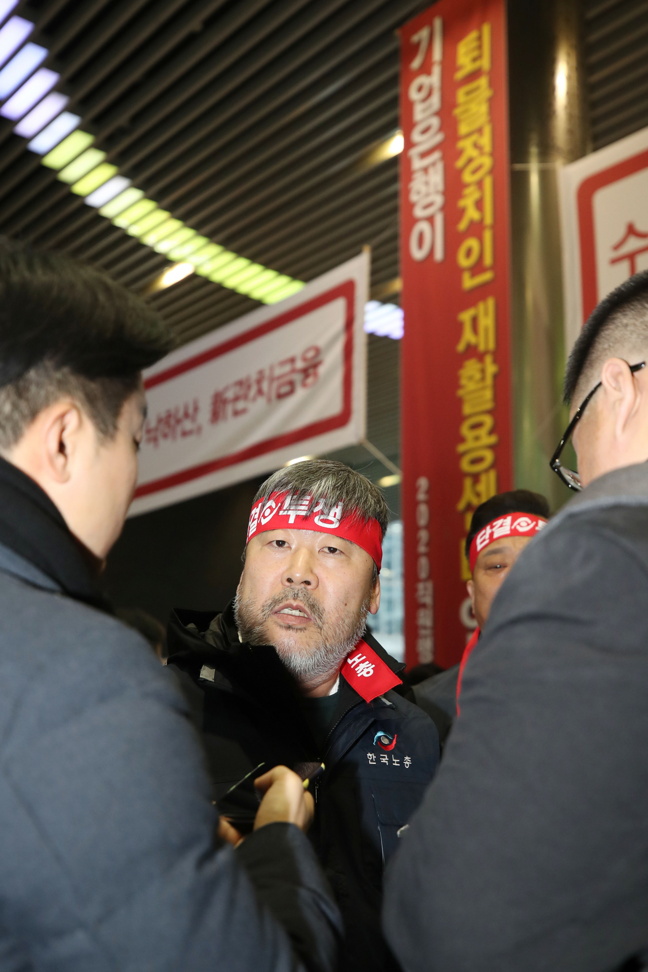 김동명 신임 한국노총 위원장이 22일 오전 서울 중구 IBK기업은행 본점 로비에서 열린 ‘기업은행 노조의 윤종원 신임 기업은행장 출근 저지 집회’에 참석한 뒤 취재진의 질문에 답하고 있다. 김 위원장은 지난 21일 당선 직후에 이어 이틀째 내리 기업은행을 찾았다. [연합]