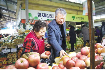 이인호(오른쪽) 한국무역보험공사 사장이 설 명절을 앞두고 21일 서울 서대문구 홍제동 인왕시장을 방문, 성수품을 구매하고 있다. ［한국무역보험공사 제공］