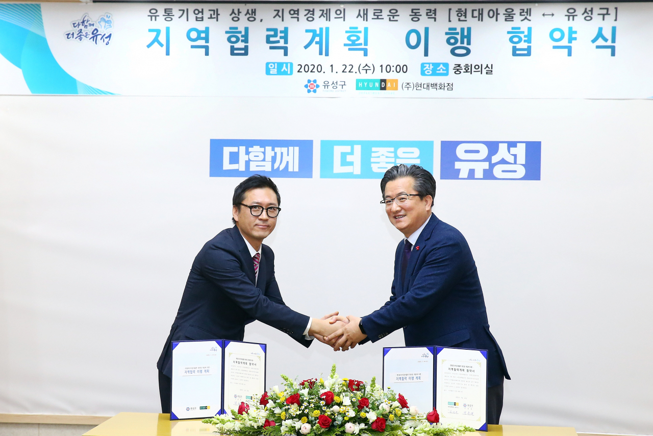 22일 오전 정용럐 유성구청장(오른쪽)이 구청 중회의실에서 (주)현대백화점 최정규 점장(왼쪽)과 지역협력계획 이행을 위한 협약을 맺고 기념촬영을 하고 있다.