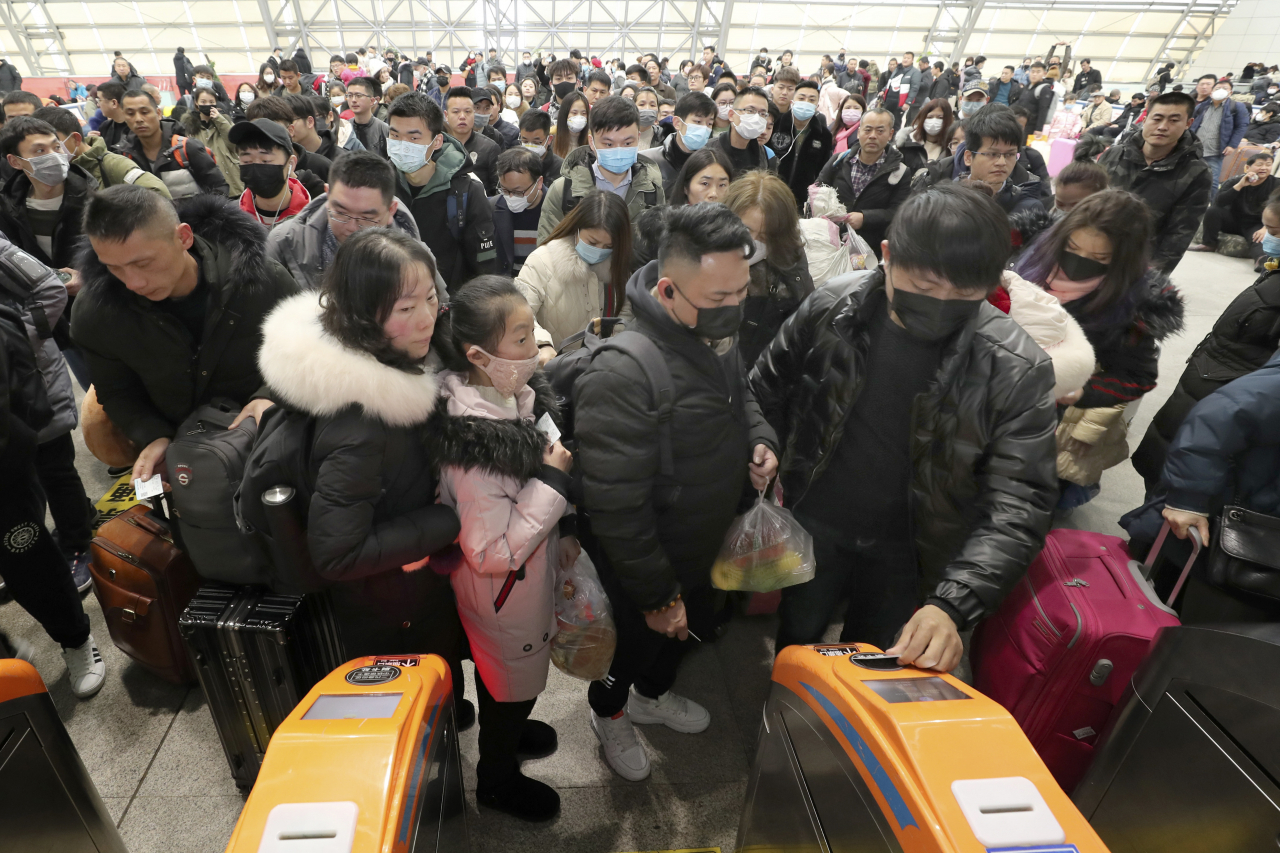 우한 페렴이 중국 전역은 물론 아시아, 미국까지 확산된 가운데 중국 최대 명절 춘절을 앞두고 우려의 목소리가 쏟아지고 있다. 사진은 22일 중국 동부 장쑤성 난퉁의 한 기차역에서 마스크를 쓴 여행객들이 개찰구에서 줄을 서 있는 모습. [AP]