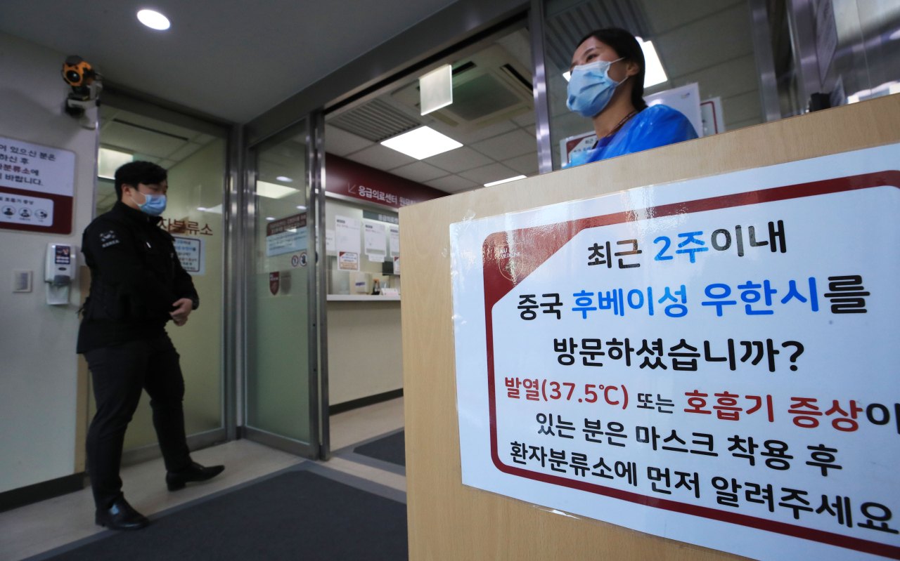 A notice with instructions for people displaying symptoms with a history of visiting Wuhan within the past two weeks is seen at an emergency room at a hospital in Seoul on Wednesday. Yonhap