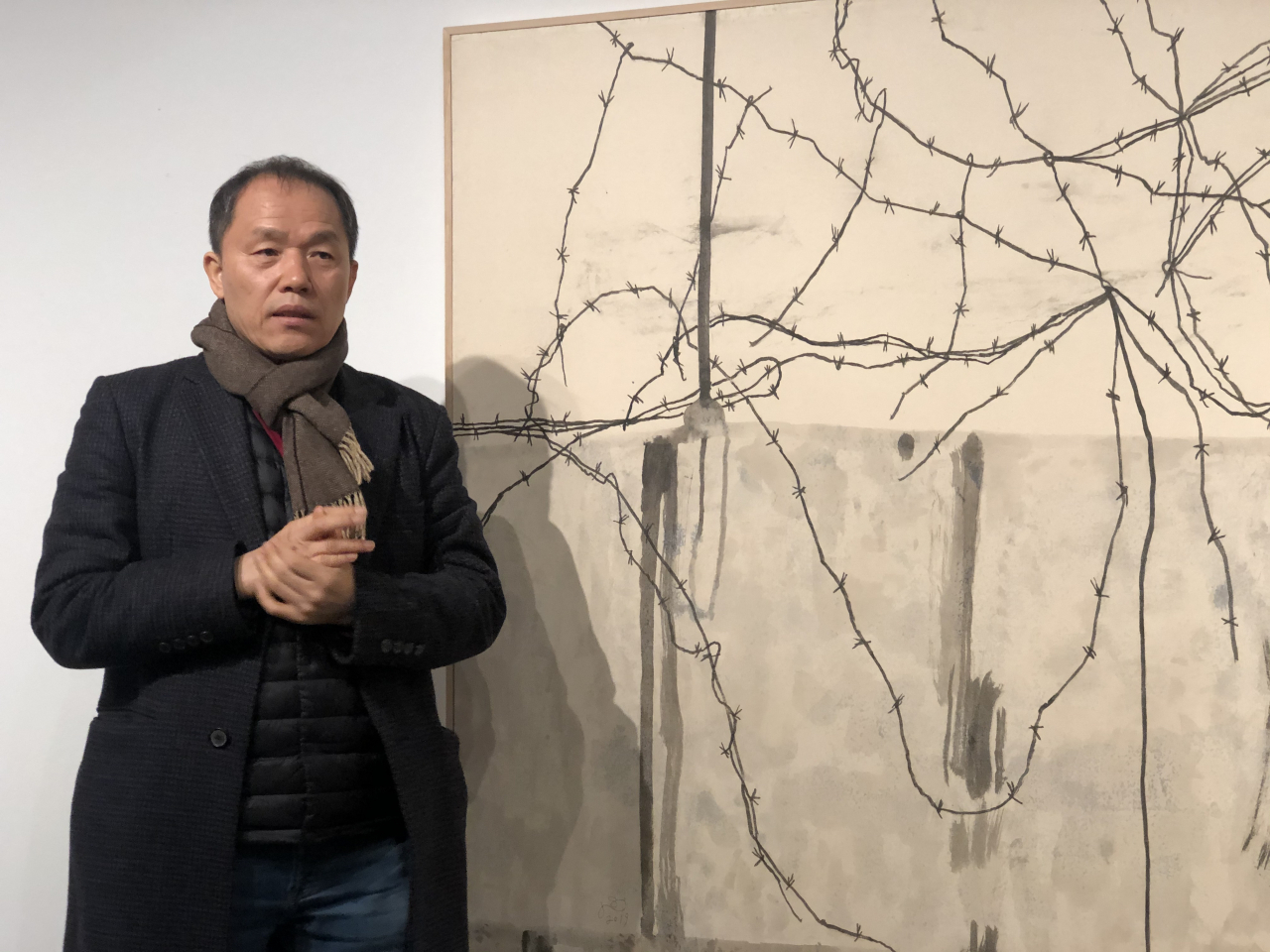 자신의 작품 '철조망 블루스'앞에 선 한국화가 김선두. 그의 개인전이 서울 삼청동 학고재갤러리에서 열린다. 이 자리에서 작가는 "한국화가 어떻게 해야 동시대를 담아낼 수 있을 것인가에 대한 고민은 비단 한국화만의 그것이 아니다. 전통과 현대의 키워드는 모든 작가들의 고민"이라고 말했다. [사진=헤럴드DB]