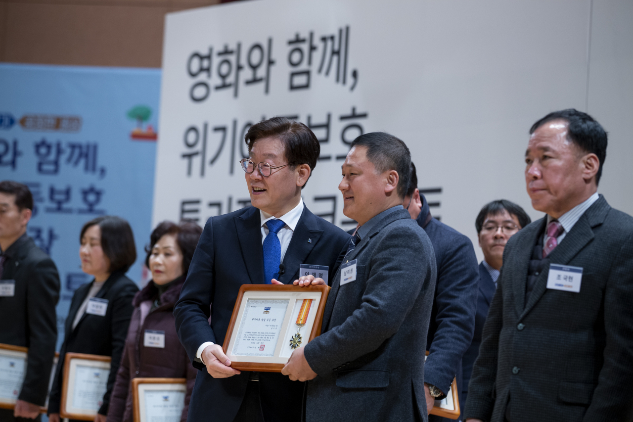 이재명 경기도지사가 ‘영화와 함께, 위기아동보호 토크콘서트’에 참석해 통리장 위기아동 발굴 유공자에 대한 표창장 시상을 하고 기념촬영을 하고 있다. [이재명 경기도지사 SNS 캡처]