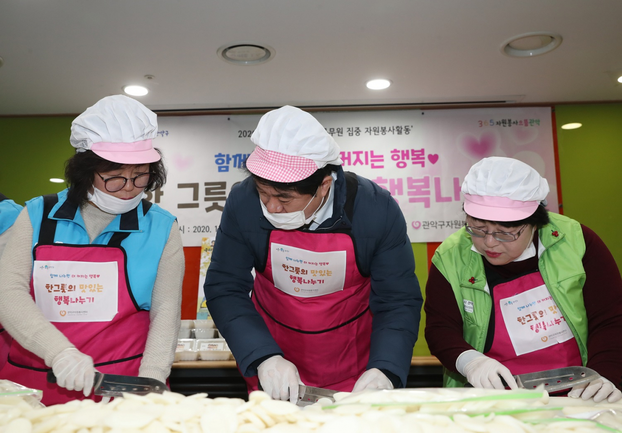 지난 22일 자원봉사센터 교육실에서 박준희 구청장이 자원봉사자들과 함께 설맞이 떡국 떡 썰기 자원봉사를 하고 있다. [관악구 제공]