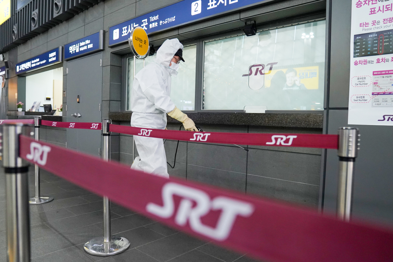 Wearing protective gear, a worker at Suseo Station disinfect the ticket office area for the SRT bullet train, amid heightened concern over the spread of Wuhan coronavius ahead of the Lunar New Year holidays on Thursday. (Yonhap)