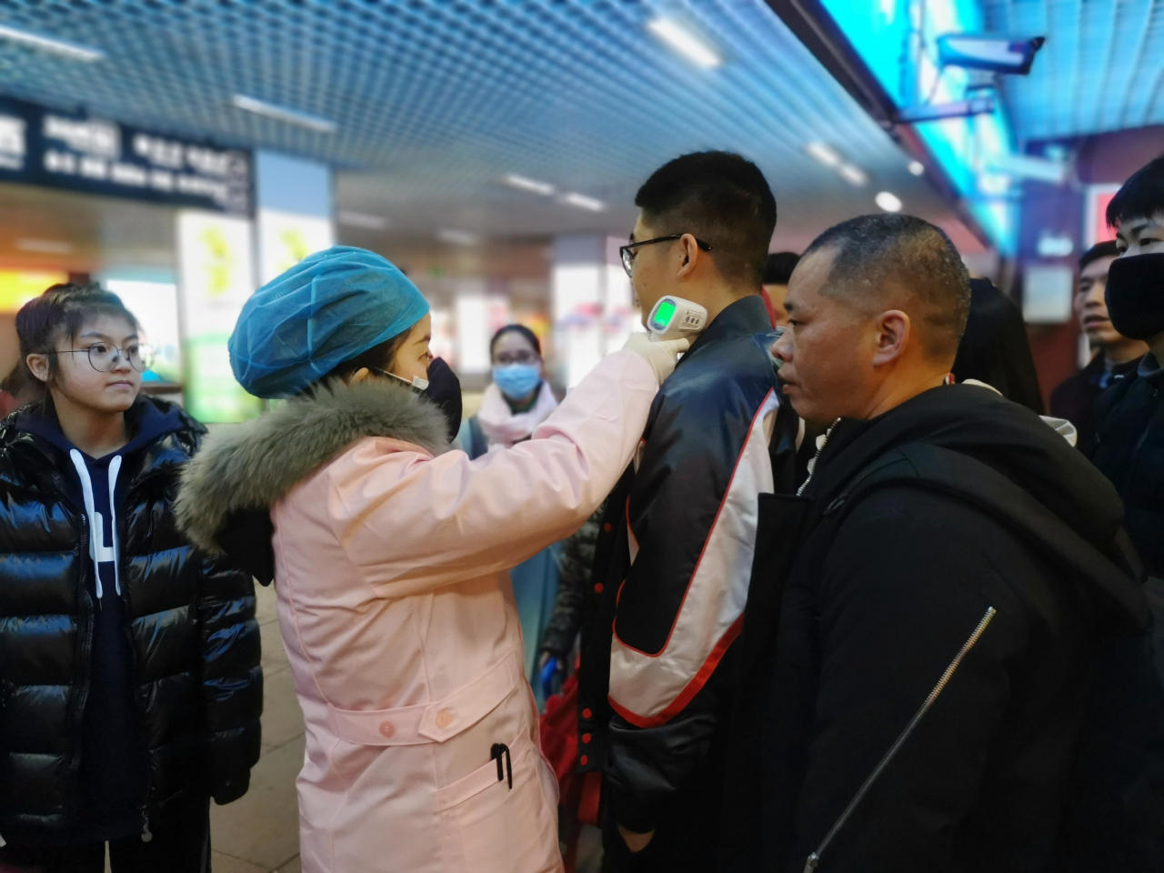 중국 정부가 신종 코로나바이러스 발생 근원지인 우한지역을 봉쇄한 가운데 이곳의 폐렴 환자들이 의료시설이 부족해 제 때 입원·격리치료를 받지 못하고 있다. 사진은 중국 장시성 잉탄시의 한 철도역에 도착하는 승객들의 체온을 체크하는 모습. [EPA]